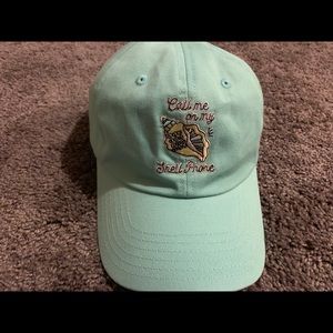 A turquoise hat with a sea shell design